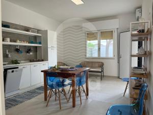 eine Küche und ein Esszimmer mit Tisch und Stühlen in der Unterkunft Villetta Carmine By Cala Salento in Torre Lapillo
