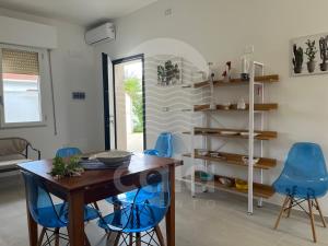 ein Esszimmer mit einem Holztisch und blauen Stühlen in der Unterkunft Villetta Carmine By Cala Salento in Torre Lapillo + 44 Fotos