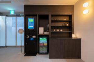 a drink vending machine next to a counter with drinks at Aank Hotel Osan in Osan