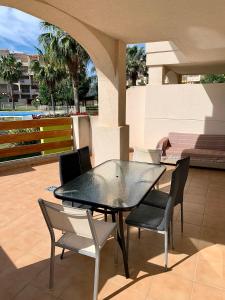 a black table and chairs on a patio with a pool at Planta baja Playa Sol 2 in Denia