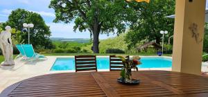 a table with a vase of flowers on top of a wooden table at La Chênaie in Sainte-Marthe