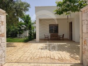 eine Terrasse eines Hauses mit einem Tisch und Stühlen in der Unterkunft Villetta Carmine By Cala Salento in Torre Lapillo
