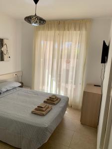 a bedroom with a bed with towels on it at Planta baja Playa Sol 2 in Denia