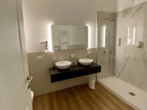 a bathroom with two sinks and a shower at Hotel Pai in Torri del Benaco