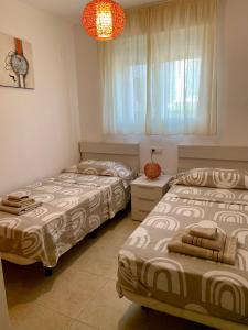 a bedroom with two beds and a window at Planta baja Playa Sol 2 in Denia
