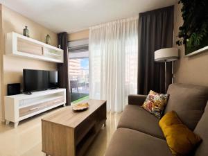 uma sala de estar com um sofá e uma televisão em Tropical y Lujoso Complejo em Oropesa del Mar