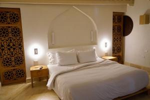 a bedroom with a large white bed with an arch above it at VILLA MERIDA BOUTIQUE HOTEL - Adults Only in Mérida