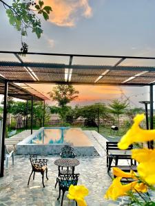 eine Terrasse mit Tischen und Stühlen neben einem Pool in der Unterkunft Rang Robin Farmstay with swimming pool in Ban Wang Muang
