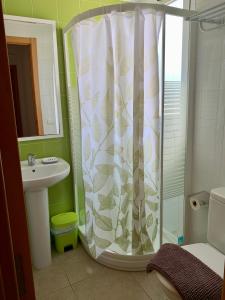 a bathroom with a shower curtain and a sink at Planta baja Playa Sol 2 in Denia