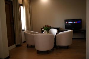 Zimmer mit einem Tisch, Stühlen und einem TV in der Unterkunft 东都明月酒店Dong Do Minh Nguyet in Bồ Sơn