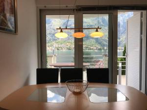a dining room table with chairs and a large window at Two bedroom Apartment in Kotor Bay in Muo