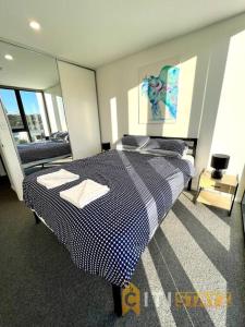 1 dormitorio con 1 cama con una manta azul y blanca a cuadros en Fab in Phillip - 2bd 2bth Apt - Close to CBR Hospital, en Phillip
