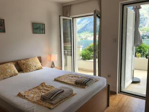 a bedroom with a large bed with a large window at Two bedroom Apartment in Kotor Bay in Muo