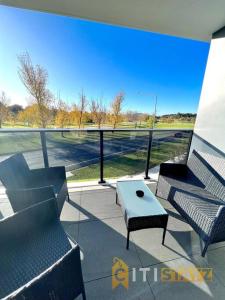 a patio with chairs and a table and a view of a field at Fab in Phillip - 2bd 2bth Apt - Close to CBR Hospital in Phillip