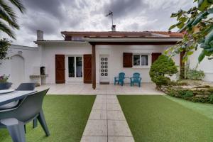 Biały dom z patio i zieloną trawą w obiekcie La Casa Bohème - Superbe maison avec parking privé w mieście Bordeaux