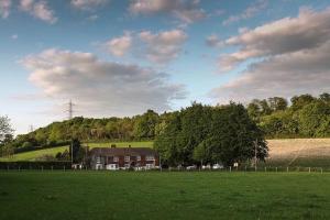 una casa in mezzo a un campo verde di The Calf Shed at Broxhall Farm a Canterbury