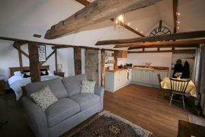 a living room with a couch and a kitchen at The Calf Shed at Broxhall Farm in Canterbury