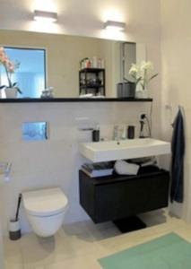 a bathroom with a white toilet and a sink at Wohnung im Trendquartier zentral - 24-7 check-in with keybox in Zurich +4 photos