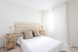 Un dormitorio blanco con una gran cama blanca y una mesa en EDEN RENTALS Ocean Poris Pearl en Poris de Abona