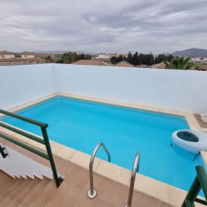 - une grande piscine bleue au-dessus d'un bâtiment dans l'établissement Ático dúplex con piscina privada en Vera Playa, à Vera