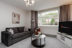 a living room with a couch and a tv at The Serenity, Three bedroom house, Preston in Walton le Dale