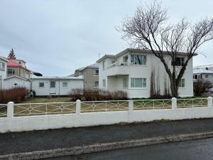una cerca blanca frente a una casa blanca en Norðurgata 43 en Akureyri