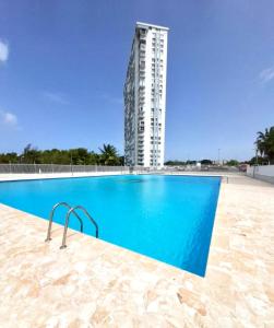 a swimming pool with a tall building in the background at The Vue at Dos Marina in Fajardo