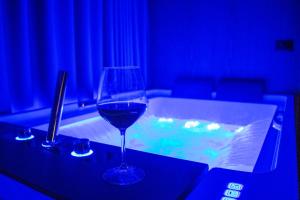 a glass of wine sitting on a table next to a tub at Bocca Hotel Korce in Korçë