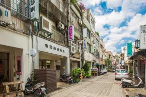 ulica w azjatyckim mieście z budynkami i motocyklami w obiekcie Guide Hotel Taoyuan Fuxing w mieście Taoyuan