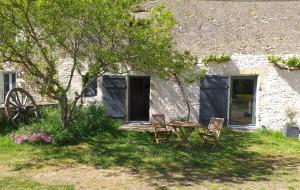einen Tisch und zwei Stühle vor einem Haus in der Unterkunft Gite du moulin in La Mothe-Saint-Héray