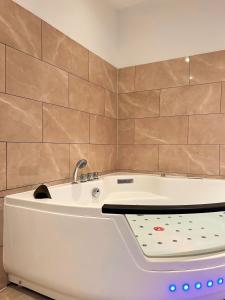a white bath tub with a sink in a bathroom at Modern SPA - Cosy & Chic - JACCUZI in Brunoy