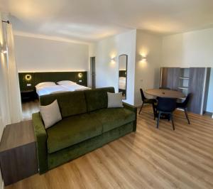 salon z kanapą, łóżkiem i stołem w obiekcie Hotel Pai w mieście Torri del Benaco