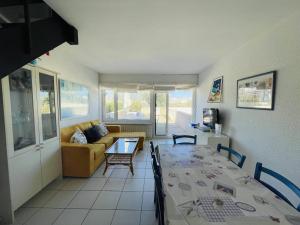 ein Wohnzimmer mit einem Tisch und einem Sofa in der Unterkunft Appartement Cap d'Agde, 4 pièces, 8 personnes - FR-1-723-27 in Bizanos