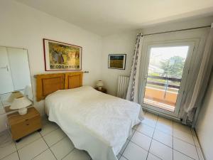 um quarto com uma cama e uma grande janela em Appartement Cap d'Agde, 4 pièces, 8 personnes - FR-1-723-27 em Bizanos