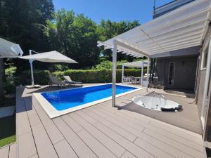 un patio con piscina y sombrilla en フレッチア, en Futo