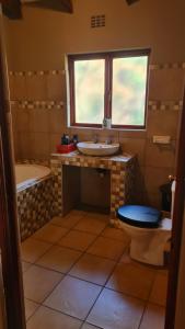 baño con 2 lavabos, aseo y ventana en The Captain en Pretoria