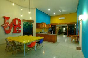 Snooze Malang في مالانغ: مطبخ كبير مع طاولة وكراسي صفراء