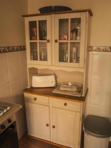 a kitchen with white cabinets and a toaster at Casa Mallos de Agüero in Agüero
