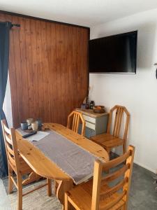 a wooden dining room table with chairs and a television at Le Skäli in Thollon +8 photos