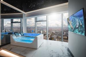 uma casa de banho com banheira num quarto com janelas em In The Sky - Apartamenty w Sky Tower em Breslávia