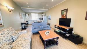 a living room with a couch and a tv at Lifestyle Villa at Pinnacle in Mossel Bay