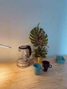 a table with a blender and a vase with flowers at SH Accademia in Carrara