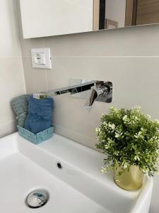 a bathroom sink with a vase of flowers on it at SH Accademia in Carrara +11 photos