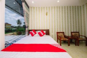 a bedroom with a bed with red pillows on it at OYO 1117 Ngoc Lan Motel in Hue