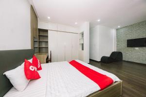 a bedroom with a large bed with red and white pillows at OYO 1117 Ngoc Lan Motel in Hue