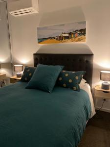 a bedroom with a green bed with a painting on the wall at Beachside Apartment 108 in McCrae