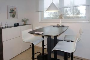małą kuchnię ze stołem i białymi krzesłami w obiekcie FIP Park Weitblick w mieście Gollwitz