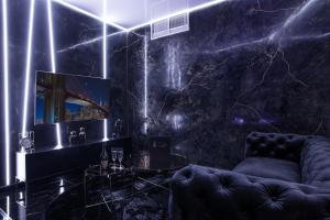 a dark room with a couch and a table at In The Sky - Apartamenty w Sky Tower in Wrocław