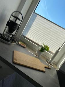 a kitchen counter with a cutting board and a window at FeWo an der Nordseeküste I in Wilhelmshaven