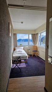 a bedroom with a bed and a large window at Sognefjord Hotel in Hermansverk